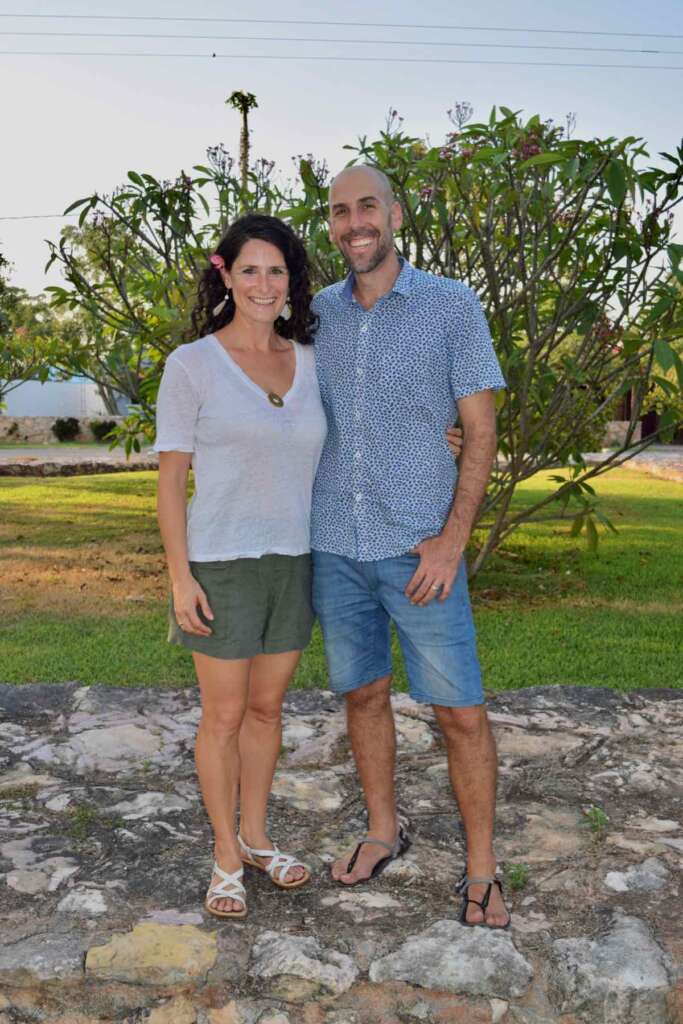 casual upright picture of daphna and michael, who run gapshealing website, in front of a frangipani tree